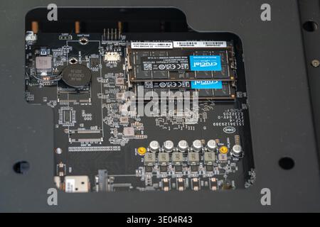 Gros plan d'une carte mère de mini-ordinateur avec des clés RAM DDR5 cruciales installées, présentant les composants matériels internes. Banque D'Images