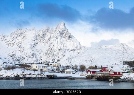Vue au lever du soleil sur les sommets rocheux et l'eau gelée de la marina Ballstad. Ballstad, Vestvagoy, Îles Lofoten, Nordland, Norvège, Scandinavie. Banque D'Images