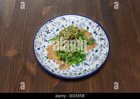 Portion de salade de wakame de style japonais, servie dans un petit bol comme plat d'accompagnement. Banque D'Images