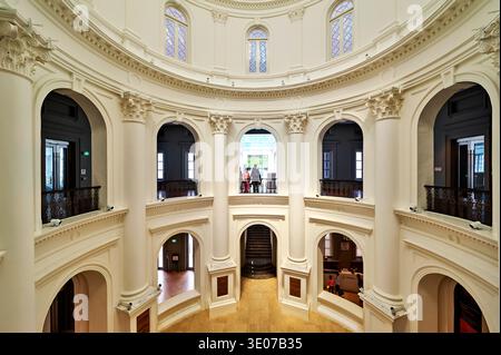 Les gens marchent et observent l'intérieur du Musée national de Singapour. L'architecture montre des caractéristiques de conception classiques. Banque D'Images