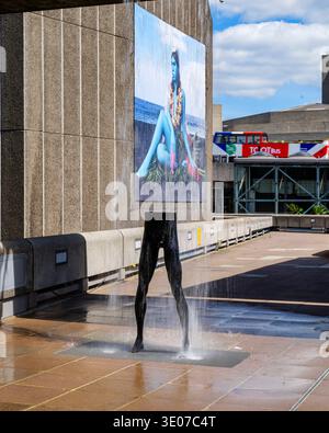 Londres - 07 09 2022 : une fontaine d'eau présente une grande œuvre d'art montrant une personne. La fontaine est située dans un quartier animé de la ville. Les gens se promènent Banque D'Images