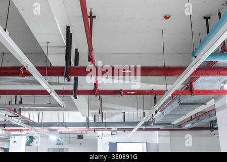Plafond de bâtiment industriel montrant des systèmes de plomberie et d'extinction d'incendie Banque D'Images