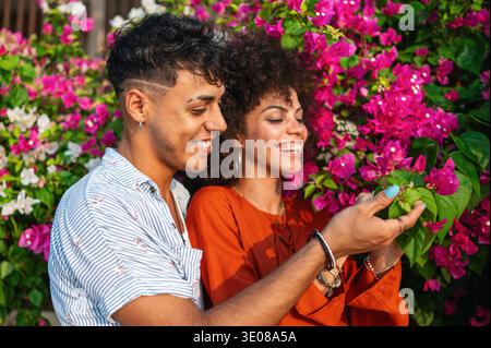 Un couple multiculturel profite d'un moment d'amour et de connexion dans un beau jardin d'été fleuri Banque D'Images