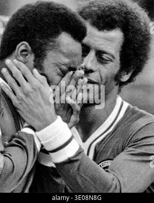 Le grand Pele couvre les yeux en pleurant lors des cérémonies du samedi 1er octobre 1977 au Giants Stadium à East Rutherford, New Jersey où il a joué son dernier match. Il est réconforté par son coéquipier Carlos Alberto, ancien capitaine de l'équipe de Coupe du monde. Banque D'Images