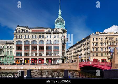 Des bâtiments historiques se dressent près de la rivière Moyka à Saint-Pétersbourg, présentant une architecture classique sous un ciel bleu avec des nuages. Banque D'Images