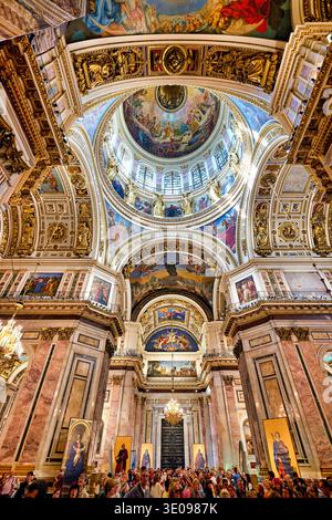 Les visiteurs se rassemblent à l'intérieur de la cathédrale d'Isaac à Pétersbourg, admirant la grande architecture et les œuvres d'art détaillées sur les plafonds et les murs. Banque D'Images