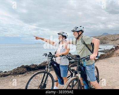 Deux personnes âgées heureux et matures appréciant et faisant du vélo ensemble pour être en forme et en bonne santé à l'extérieur. Les aînés actifs ayant une formation amusante dans la nature. Portrait Banque D'Images