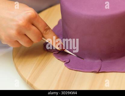 Leçon de pâtisserie, de travailler sur les chiffres de l'Halloween avec du fondant pâte ou pâte à sucre. Banque D'Images
