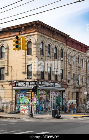 Des graffitis colorés et des peintures murales de Street art couvrent la façade du rez-de-chaussée d'un mini-marché d'angle à Bushwick, Brooklyn, New York. Banque D'Images