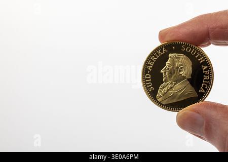 Main d'homme tenant la pièce d'or Krugerrand, portrait de Paul Kruger, détail, fond blanc, image symbolique, pièce de monnaie, retraite, taxati Banque D'Images