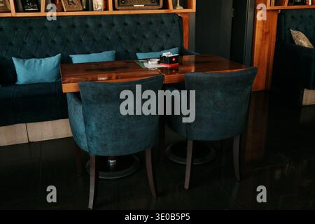 Intérieur de café moderne et confortable avec des sièges rembourrés, des tables en bois et des étagères décoratives créant une atmosphère agréable pour les repas. Bijeljina, Bosnie Banque D'Images