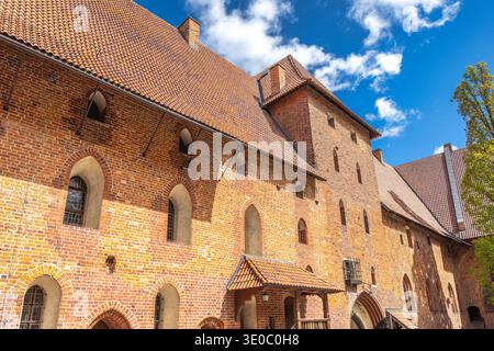 Le château de Malbork, un château gothique en briques dans le nord de la Pologne, en Europe. Majestueuse façade médiévale de château avec briques rouges, fenêtres cintrées, et Banque D'Images