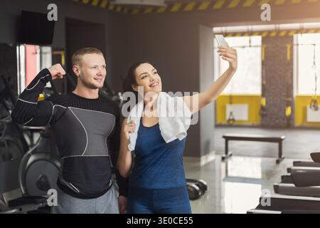 Jeune couple faisant selfie au gymnase Banque D'Images