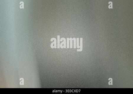 Une image floue montre un mur texturé avec différentes nuances de gris et de blanc. L'image est floue, manque de détails nets, créant un eff abstrait Banque D'Images