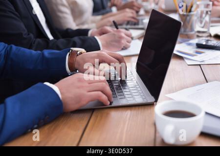 Homme d'affaires mains tapant sur ordinateur portable pendant la réunion Banque D'Images