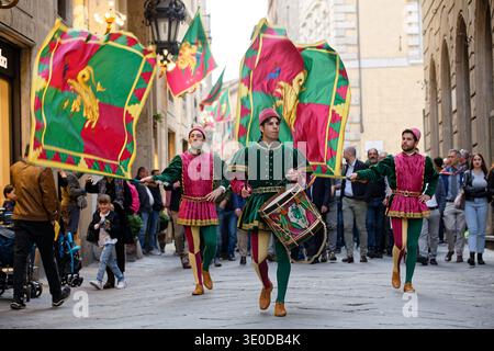 25.05.2019, Italie, Toscane, Sienne - Parade de la Contrada del Drago. Défilé traditionnel en costumes médiévaux. Les porteurs de drapeaux brandissent leurs drapeaux dans l'ol Banque D'Images