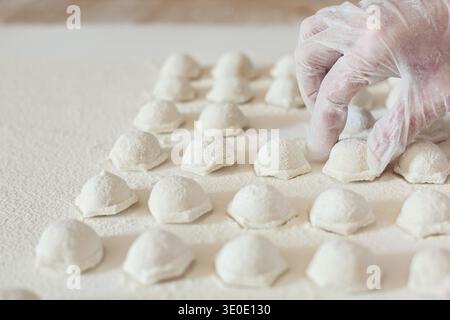 Mains de chef mettant des boulettes faites à la main sur la table Banque D'Images