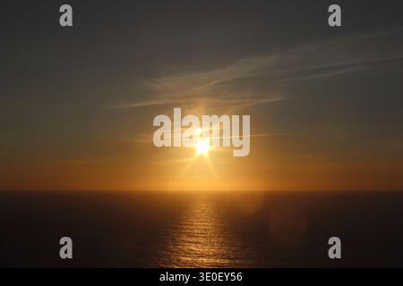 Coucher de soleil doré sur l'océan Atlantique avec Sunstar Flare et Calm Water Banque D'Images