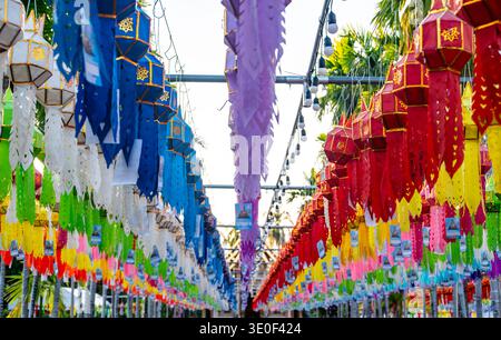 Drapeaux de prière bouddhistes colorés suspendus à l'arbre près du temple en Thaïlande. Décorations traditionnelles symbolisant les bénédictions, la paix et l'harmonie spirituelle f Banque D'Images