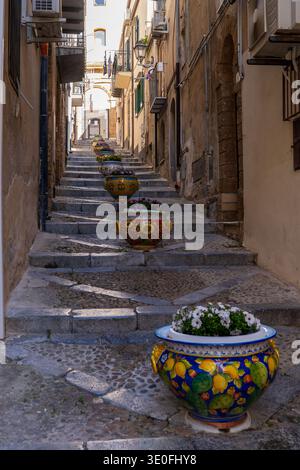Un escalier pittoresque dans le centre historique de Cefalu orné de pots en céramique sicilienne peints à la main avec des motifs citron et fleurs. La perspective à angle bas Banque D'Images