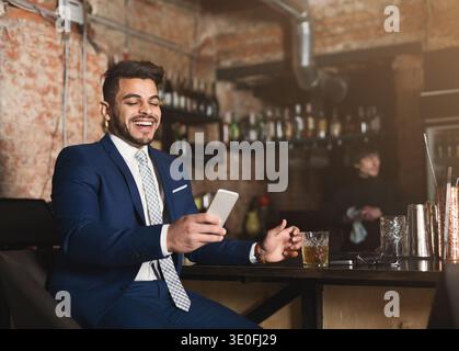 Heureux homme d'affaires se reposant dans le bar après la journée de travail Banque D'Images