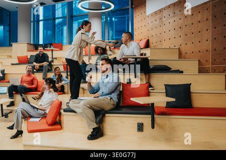 Team collabore dans un espace de coworking moderne avec des sièges détendus et une énergie vibrante Banque D'Images