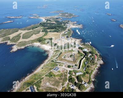 Vue aérienne d'un littoral accidenté rencontrant la mer tranquille et turquoise, parsemée de petits bateaux près du Île de Tatihou, Manche, France. Banque D'Images