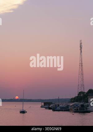 Coucher de soleil pastel sur l'eau calme avec des bateaux et yachts amarrés en Lettonie Banque D'Images