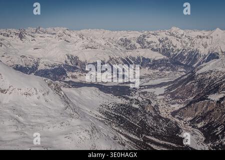Nous volons au-dessus de Diavolezza en regardant en arrière vers la vallée de l'Engadine avec Samedan clairement visible. 3/2026 Banque D'Images