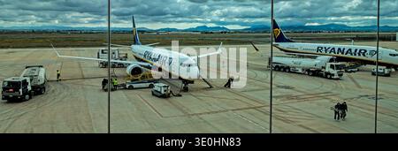 Ryanair Boeing 737 sur le tarmac de l'aéroport de Murcie, en Espagne, entretenu par des camions-citernes et des équipages au sol sous un ciel nuageux spectaculaire. Banque D'Images