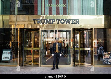 Portier en uniforme dans des gants blancs se tient aux portes d'entrée tournantes or de Trump Tower sur la Cinquième Avenue, Manhattan, New York City, États-Unis Banque D'Images