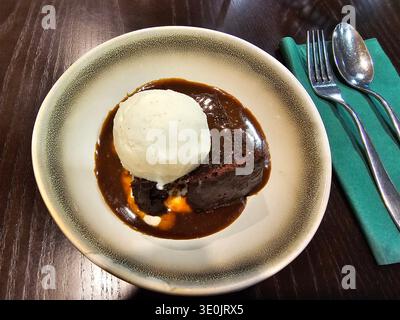 Pudding au caramel collant accompagné de glace à la vanille, un dessert britannique traditionnel populaire. Banque D'Images