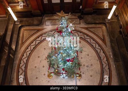 Vue aérienne d'un arbre de Noël décoré sur un sol en mosaïque à l'intérieur de l'atrium Art Nouveau historique de Hôtel PaMS, Perpignan, France. Banque D'Images