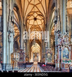 Les visiteurs explorent l'intérieur de la cathédrale d'Étienne à Vienne, en Autriche, en observant le design gothique détaillé et religieux Banque D'Images