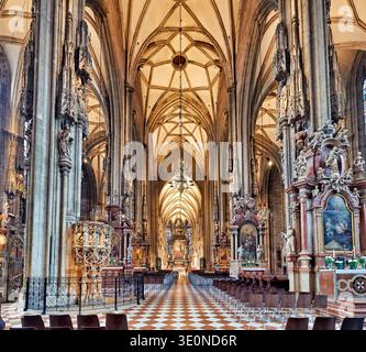Les visiteurs explorent l'intérieur de la cathédrale d'Étienne à Vienne. Le superbe design gothique présente de hauts plafonds et des autels détaillés. Banque D'Images