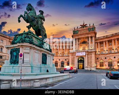 Le coucher du soleil brille sur le palais de Hofburg à Vienne, en Autriche, révélant la statue équestre du prince Eugène de Savoie contre un ciel coloré. Banque D'Images