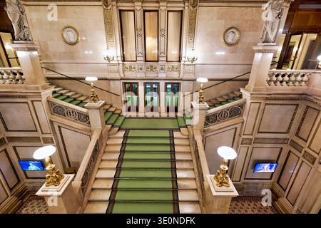 Les visiteurs peuvent admirer le grand escalier de l'Opéra national de Vienne avec ses statues et son design élégant. Le tapis vert descend les escaliers. Banque D'Images