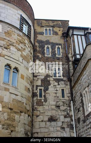 Gros plan de la tour médiévale Byward Tower de la Tour de Londres, présentant une ancienne maçonnerie en silex et en pierre, des fenêtres étroites en boucle de flèche et des charpentes en bois Banque D'Images