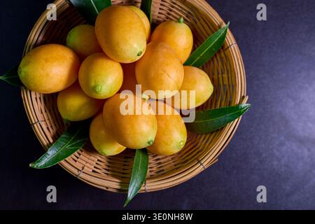 Prunes mariales fraîches dans un panier tissé Banque D'Images