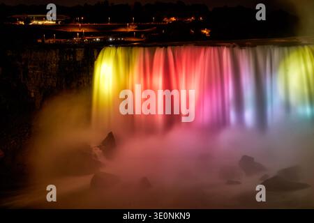 Niagara Falls, Canada, brille de lumières vibrantes la nuit, captivant les touristes réunis sur la terrasse d'observation pour une vue spectaculaire. Banque D'Images