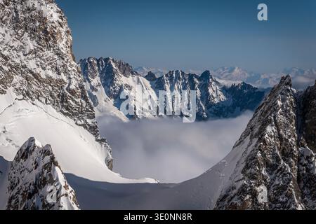 Sommets inférieurs au-dessus d'un brouillard marin lors d'un vol tôt le matin à travers le massif du Mont Blanc. 3/2026 Banque D'Images