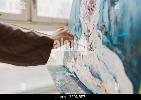 Gros plan de la peinture à la main de l'artiste féminine avec des peintures à l'huile Banque D'Images