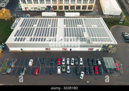 Siauliai, Lituanie - 17 novembre 2024 : voitures aériennes top down dans le parking et les clients vont faire leurs courses au supermarché allemand Lidl avec solaire Banque D'Images