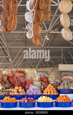 Tradition orientale rural marché de fruits en plein air étal avec piles colorées de fruits tropicaux frais disposés en pyramides et piles de paniers en osier. Sa Banque D'Images