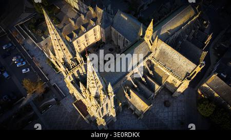 Vue aérienne des flèches de la cathédrale perçant le ciel, projetant de longues ombres sur les anciennes pierres de la place du Martray, Saint-Pol-de-Léon, Britt Banque D'Images