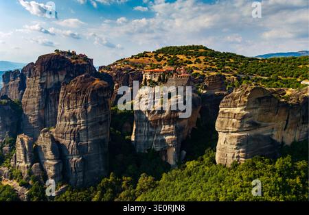 Vue aérienne des monastères perchés au sommet de formations rocheuses imposantes, où l'architecture ancienne rencontre le vaste ciel, Météores, Trikala, Grèce. Banque D'Images
