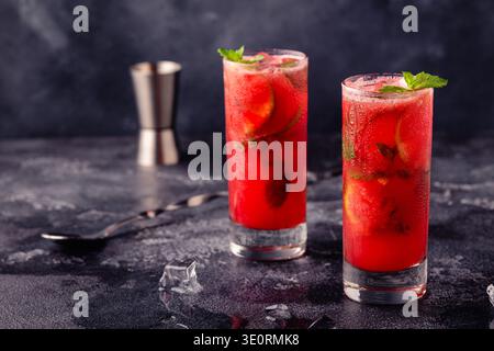 Cocktail rouge avec alcool ou sans alcool à la menthe et au citron vert. Banque D'Images