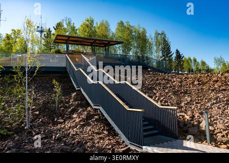 Escalier extérieur moderne menant à la terrasse d'observation sur Rocky Hillside avec des arbres et Blue Sky Banque D'Images