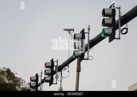 Feux de signalisation suspendus avec signaux lumineux, dispositifs de surveillance et structure de bras de mât noir Banque D'Images