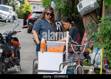 Un vendeur de rue prépare des collations aux œufs de caille kwek kwek dans un chariot mobile pendant qu'un client attend dans une rue du quartier à Cebu Philippines. Banque D'Images